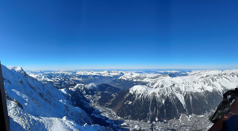 Panorama over snowy peaks and a valley town far below