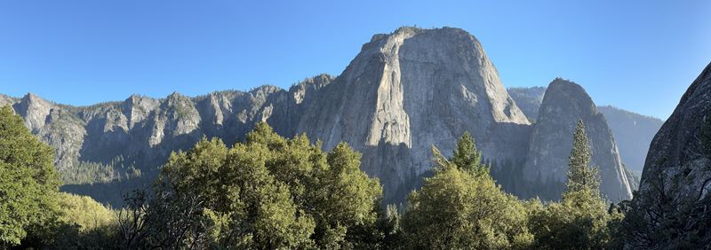 Panorama of towering granite cliffs above a forest