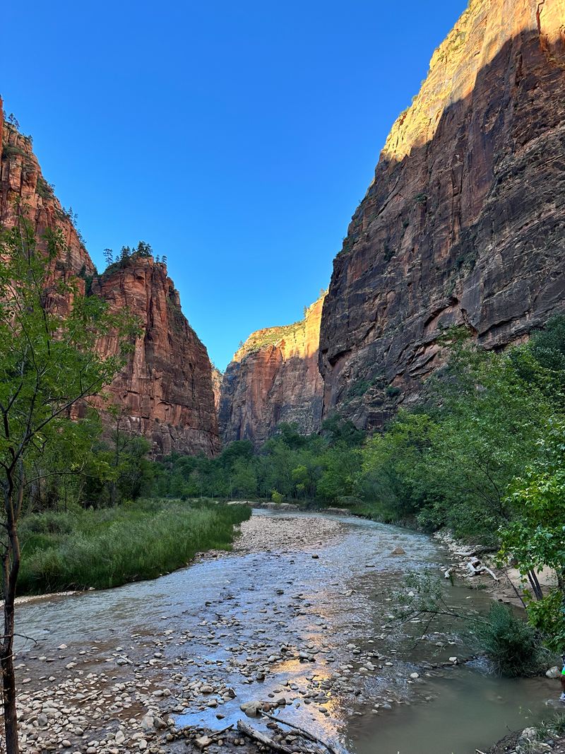 A shallow river running between red canyon walls