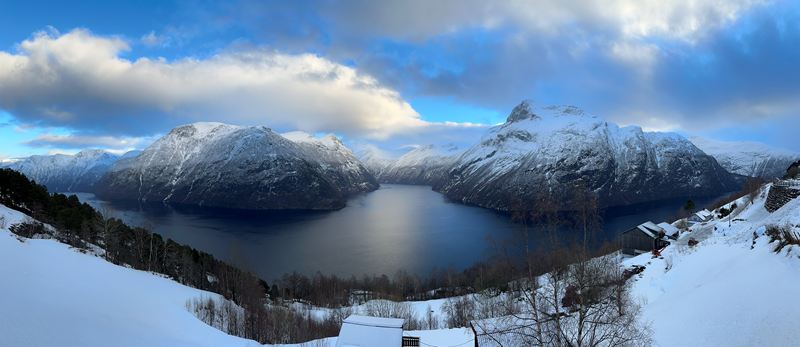 Panorama of a fjord between snow-covered mountains
