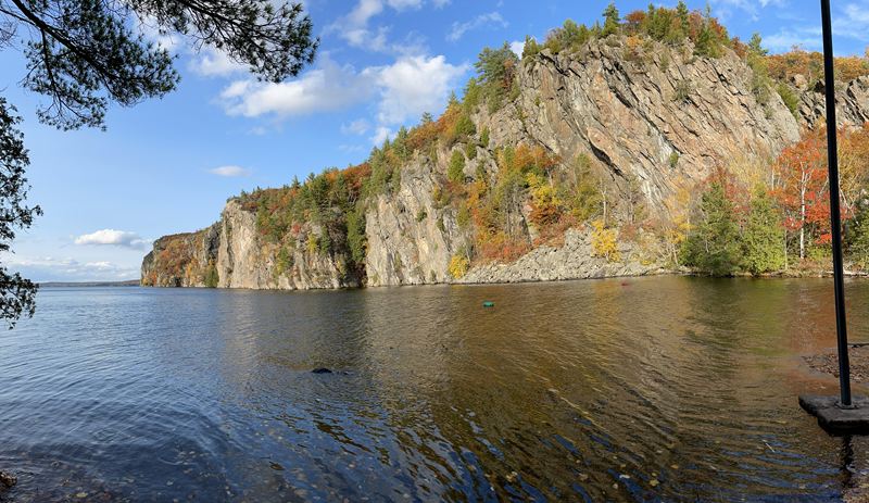 Autumn trees on a tall cliff rising out of a lake