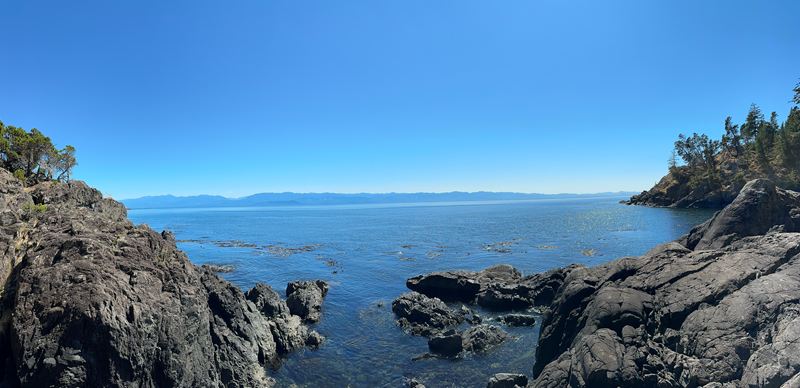 A rocky shoreline opening onto calm blue water