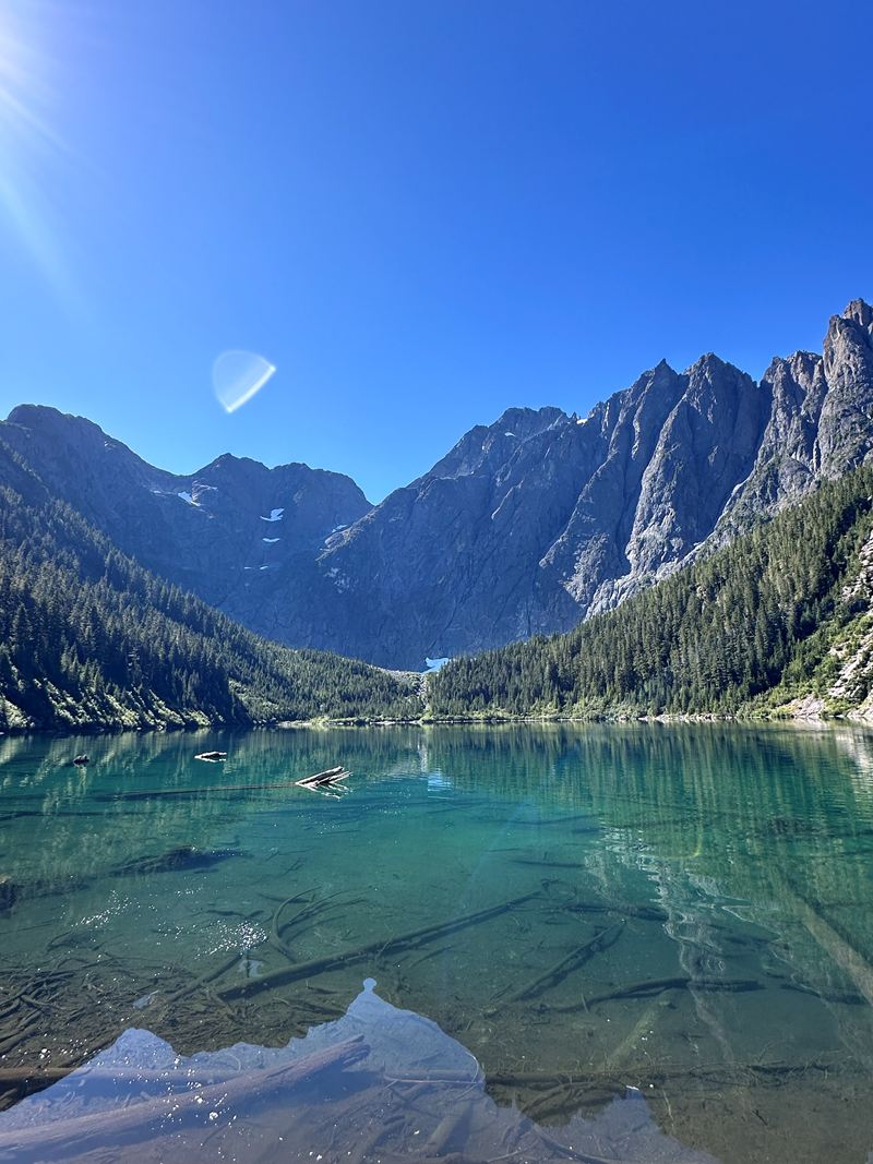 A turquoise alpine lake below jagged mountain peaks