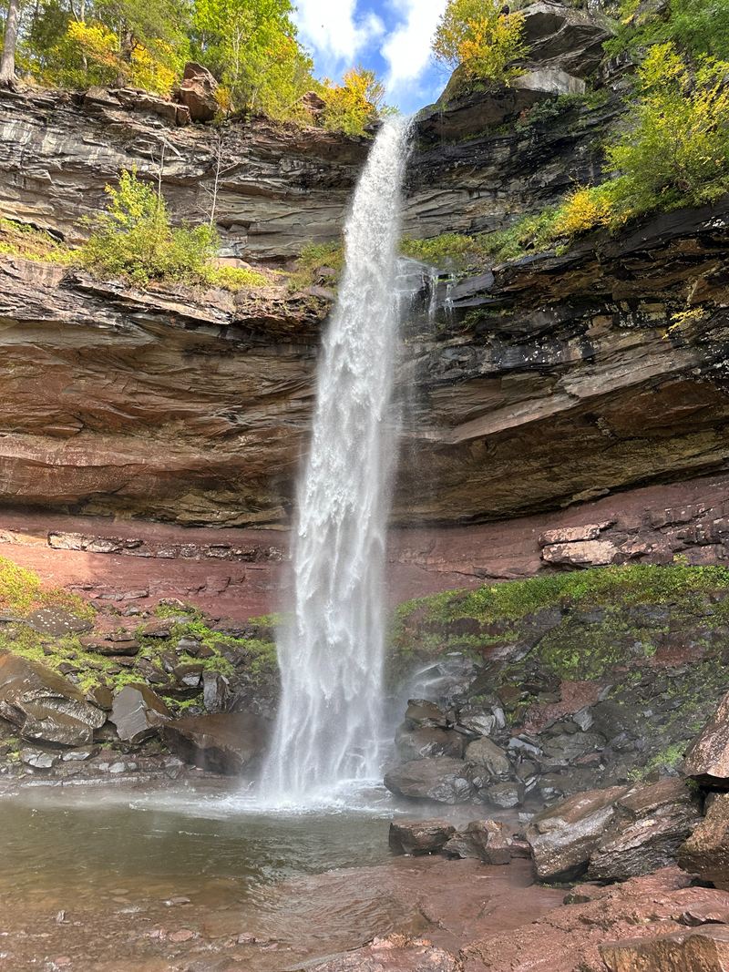 A tall waterfall pouring into a rocky gorge